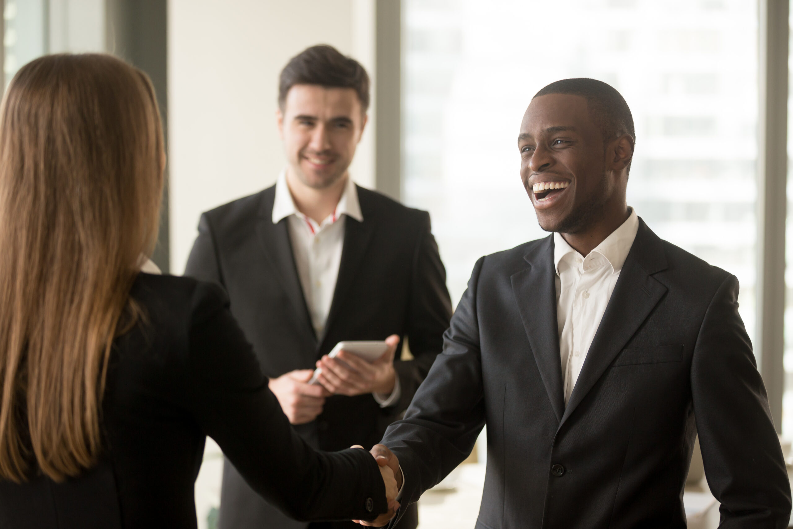 Happy,Smiling,Afro,American,Businessman,And,Caucasian,Businesswoman,Shaking,Hands